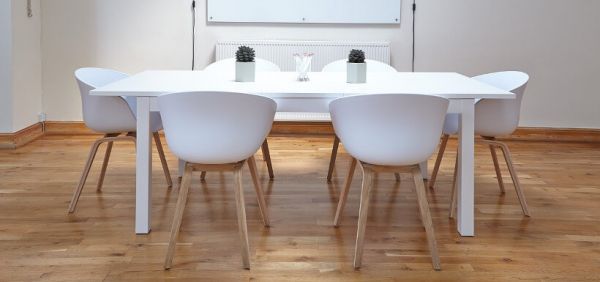 tisch mit weißen Stühlen und Whiteboard