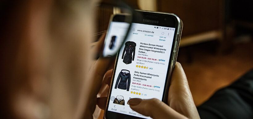 Blick über die Schulter: Frau sucht per Amazon-App nach Wintermantel
