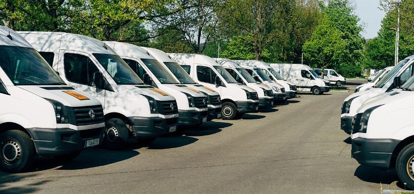 viele identische weiße Vans auf einem Parkplatz