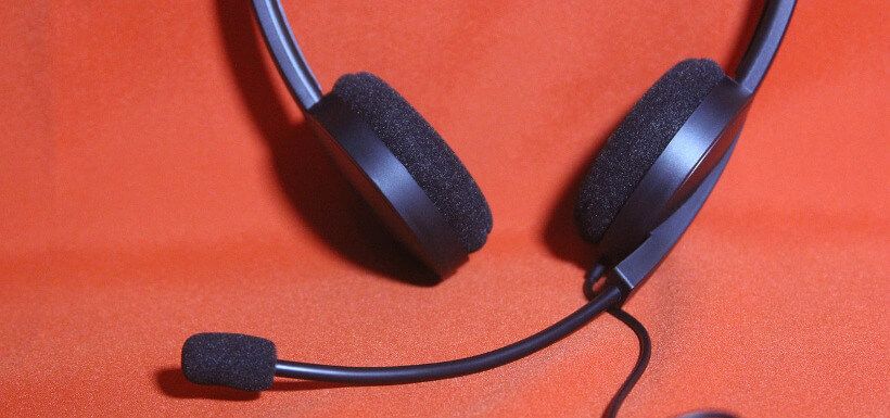 Nahaufnahme: Callcenter-Headset auf rotem Grund