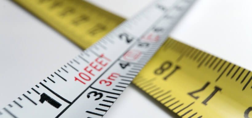 zwei Maßbänder, auf denen verschiedene Maßeinheiten (Meter und Feet) verzeichnet sind