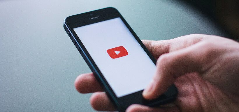 Smartphone wird in Hand gehalten und zeigt Youtube-Logo